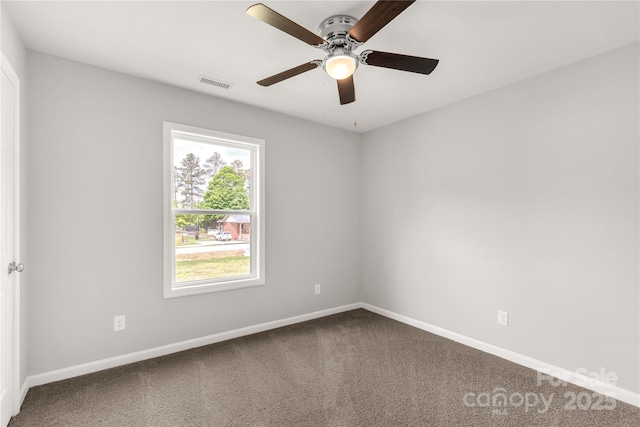 carpeted empty room with baseboards, visible vents, and a ceiling fan