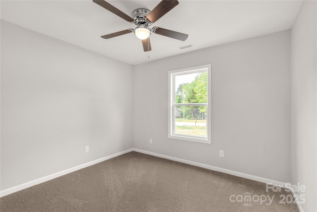 carpeted spare room featuring visible vents, ceiling fan, and baseboards