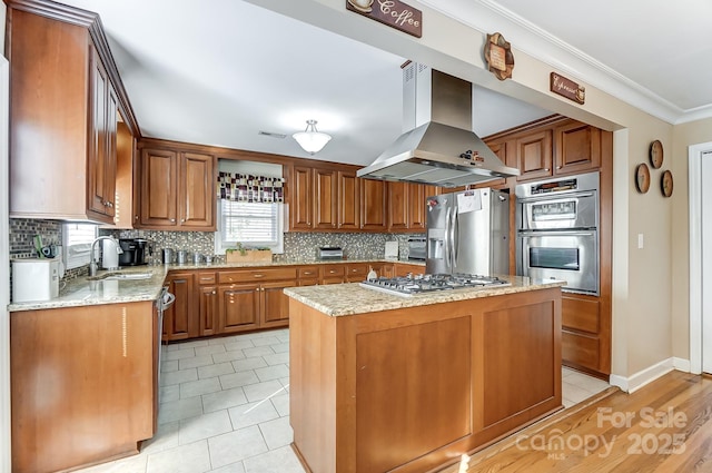 kitchen featuring sink, a center island, island exhaust hood, stainless steel appliances, and light stone countertops