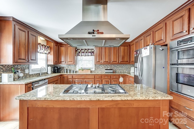 kitchen featuring light stone countertops, island range hood, stainless steel appliances, and a center island