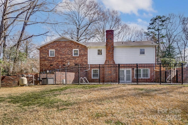 back of house featuring a lawn