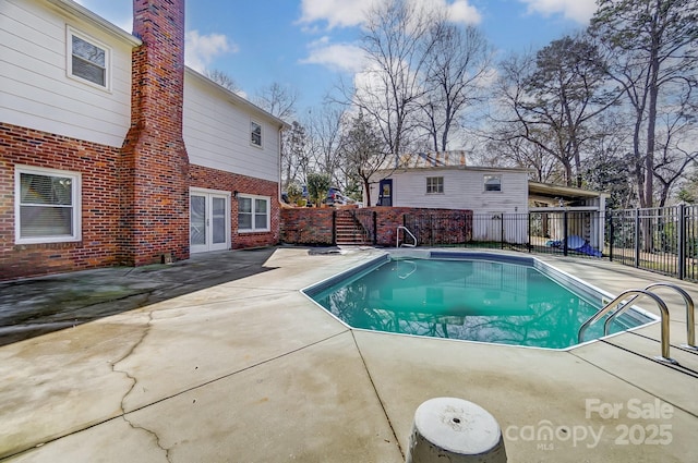 view of swimming pool featuring french doors and a patio area