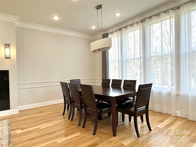 dining space featuring ornamental molding and light wood-type flooring