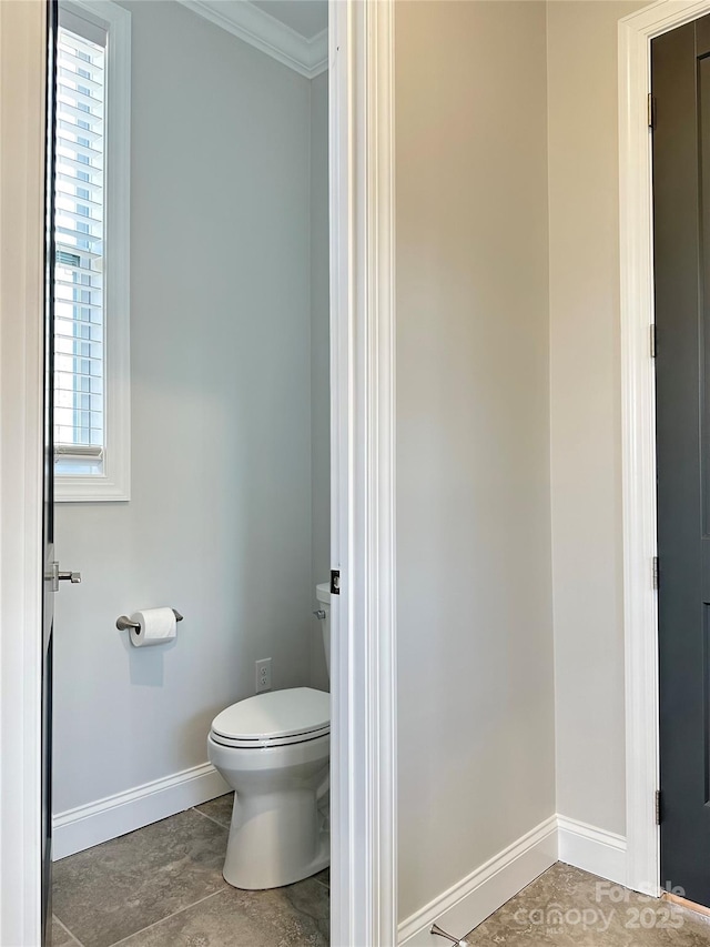 bathroom featuring crown molding and toilet