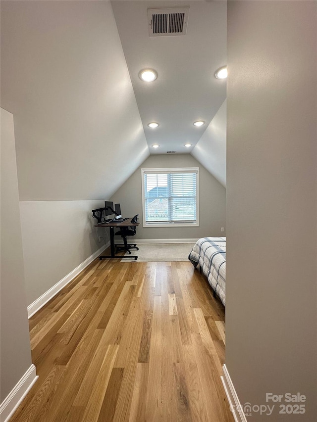 unfurnished bedroom featuring vaulted ceiling and light hardwood / wood-style flooring