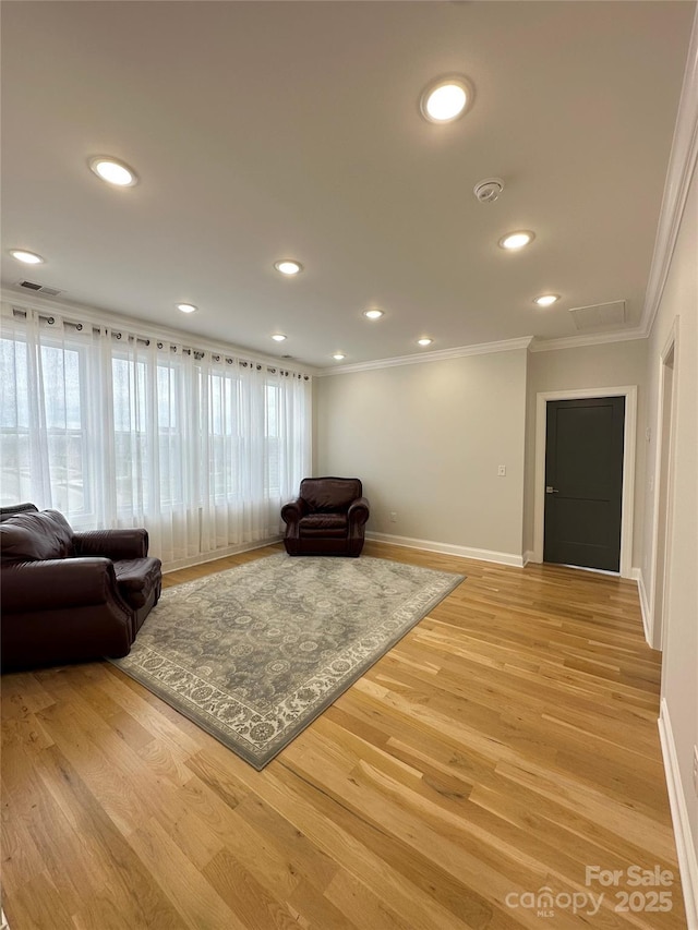 living room featuring crown molding and light hardwood / wood-style floors