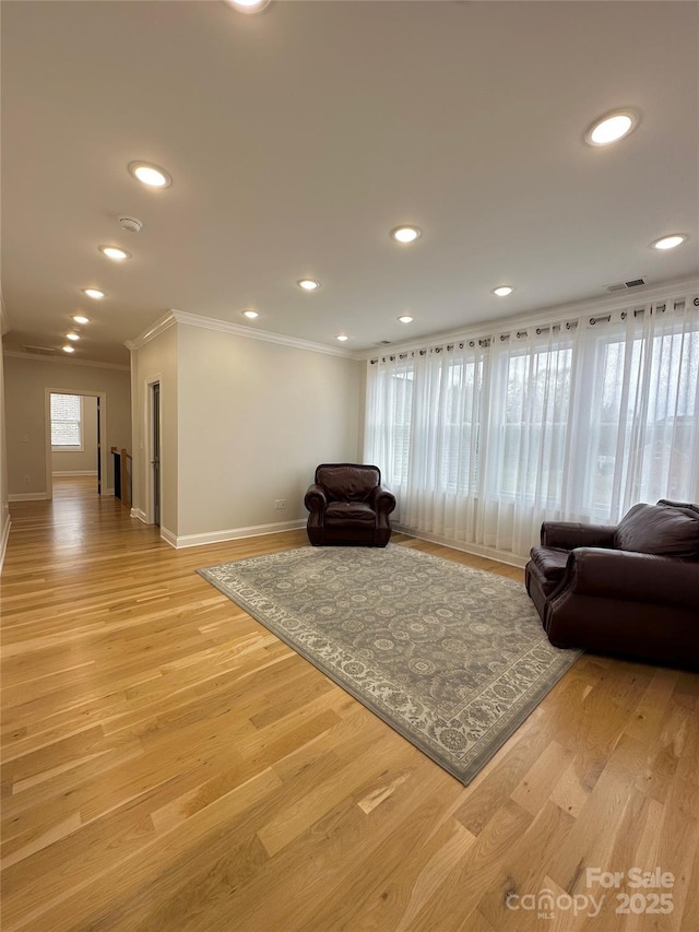 living room featuring crown molding and light hardwood / wood-style floors