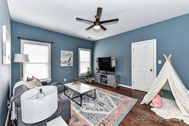 living room featuring ceiling fan and dark hardwood / wood-style flooring