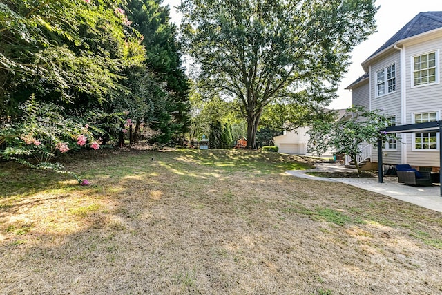 view of yard featuring a garage and a patio area