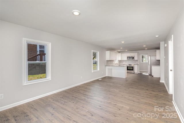 unfurnished living room with wood-type flooring and sink