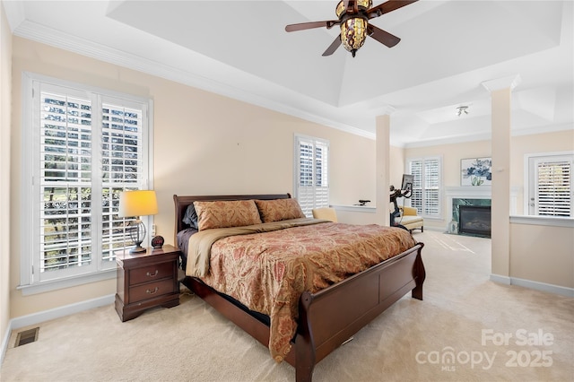 bedroom with light carpet, multiple windows, visible vents, and a raised ceiling