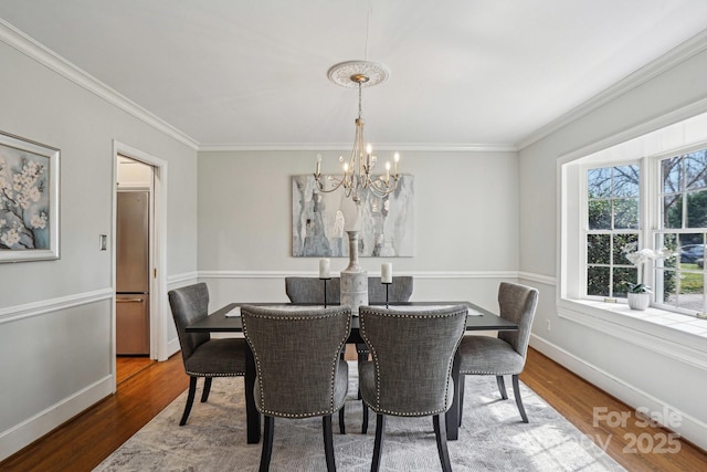 dining space featuring an inviting chandelier, baseboards, and wood finished floors