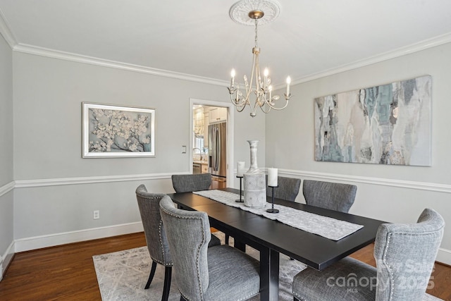 dining room with baseboards, wood finished floors, and crown molding