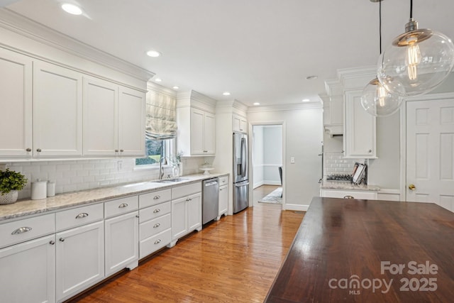 kitchen with light wood-style floors, white cabinetry, appliances with stainless steel finishes, and a sink