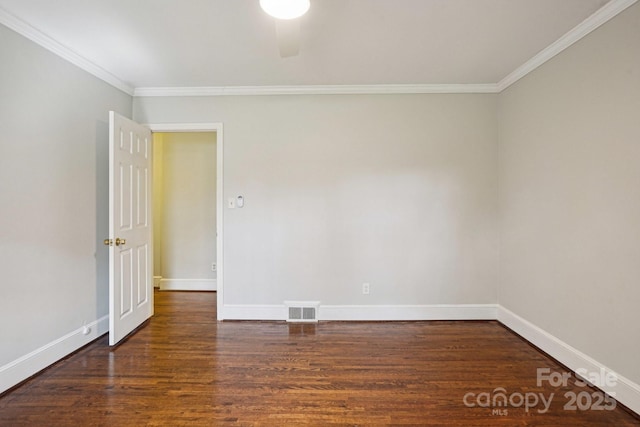 empty room featuring baseboards, visible vents, wood finished floors, and ornamental molding