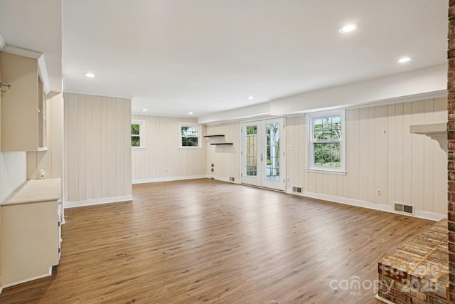 unfurnished living room featuring recessed lighting, visible vents, wood finished floors, and french doors