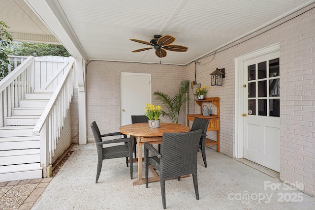 view of patio featuring outdoor dining area, stairway, and a ceiling fan