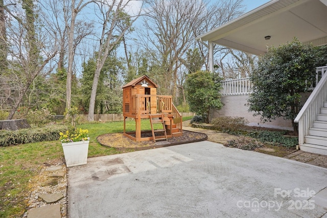 exterior space featuring a playground and fence