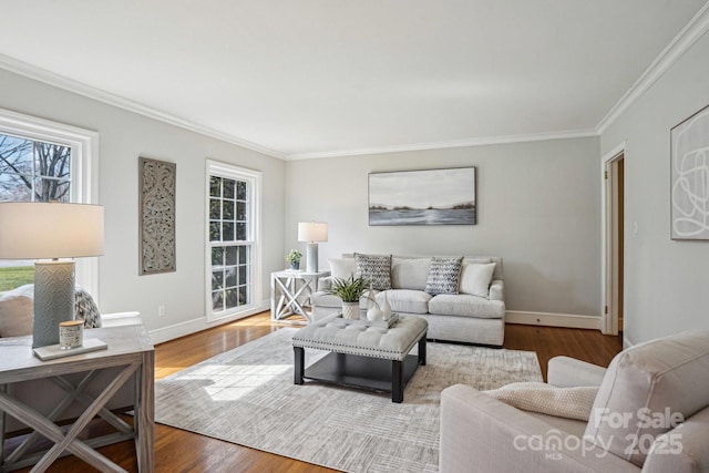 living area featuring a wealth of natural light, crown molding, baseboards, and wood finished floors