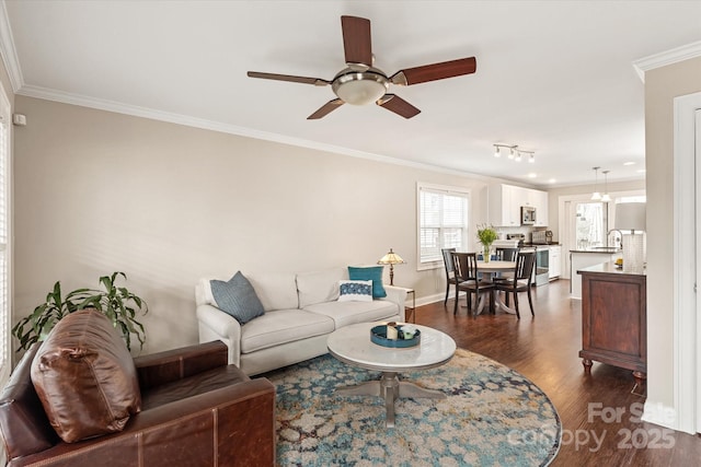 living area featuring baseboards, dark wood finished floors, a ceiling fan, and crown molding