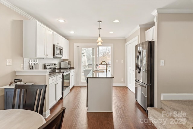 kitchen featuring pendant lighting, dark wood finished floors, appliances with stainless steel finishes, white cabinetry, and a sink