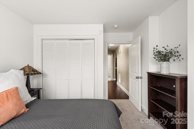 bedroom featuring light carpet, baseboards, visible vents, and a closet