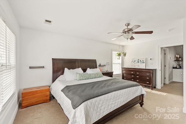 bedroom with visible vents, a ceiling fan, and light colored carpet