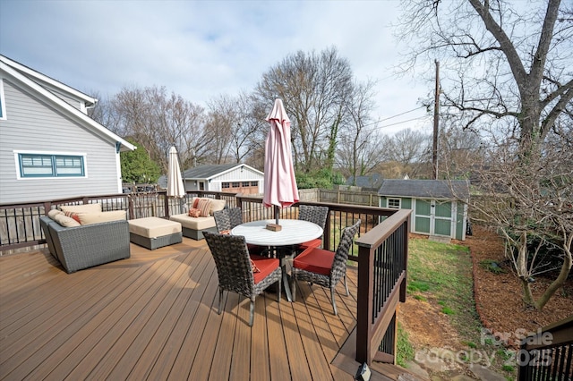 deck with an outbuilding, fence, outdoor dining area, a shed, and an outdoor living space