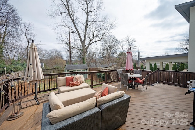 wooden deck with outdoor dining area, an outdoor structure, fence, and an outdoor hangout area