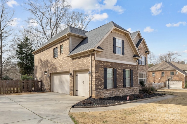 view of front of property with an attached garage, driveway, fence, and a shingled roof