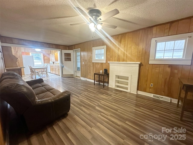 living room with a wealth of natural light, hardwood / wood-style floors, and a textured ceiling