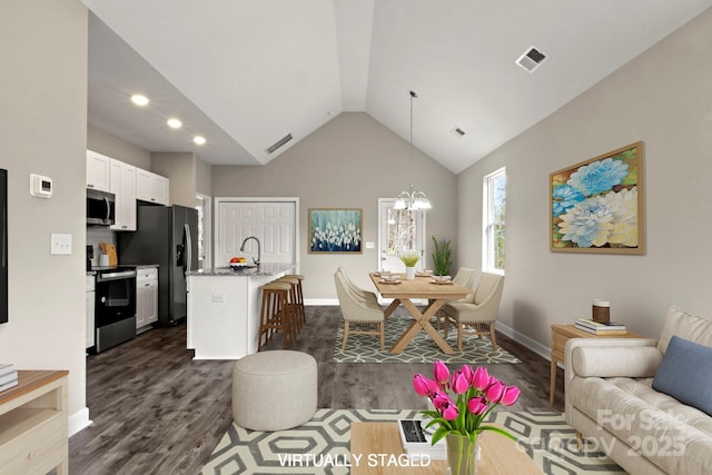 interior space with lofted ceiling, dark hardwood / wood-style floors, sink, and a notable chandelier