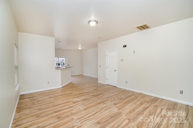 empty room with baseboards, visible vents, and light wood-style floors