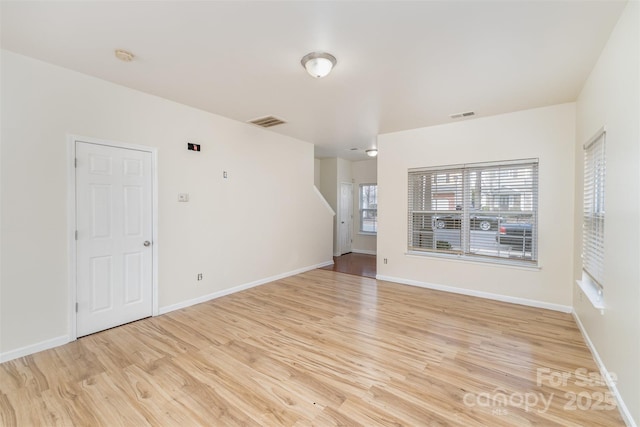 spare room with visible vents, light wood-style flooring, and baseboards