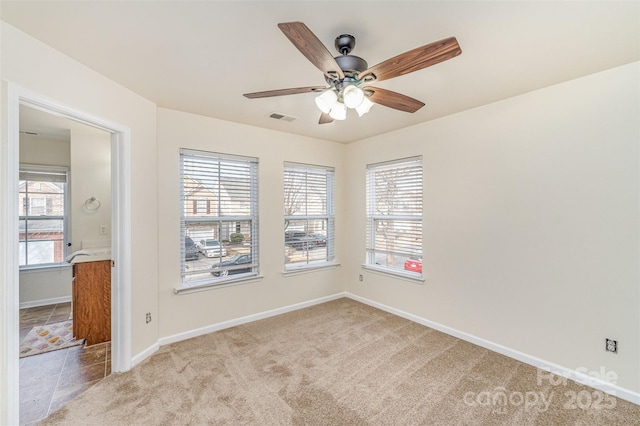 empty room featuring visible vents, ceiling fan, light carpet, and baseboards