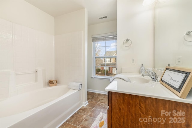 full bath featuring a tub to relax in, baseboards, visible vents, tile patterned floors, and vanity