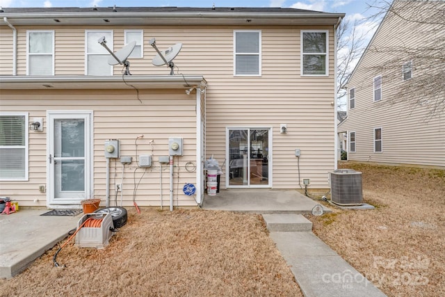 back of house featuring a lawn, a patio area, and central air condition unit