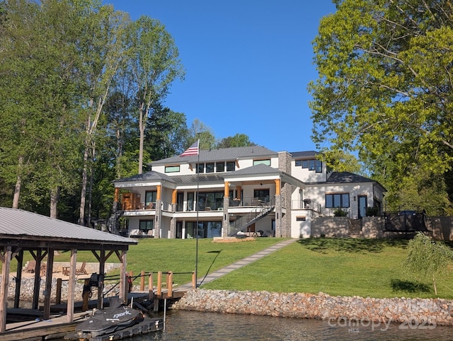 exterior space featuring metal roof, a yard, a balcony, and a water view