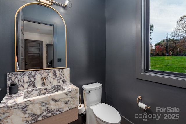 half bathroom with tasteful backsplash, toilet, and vanity