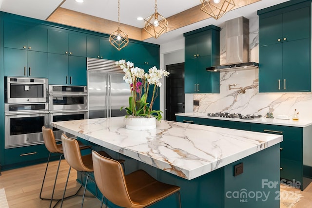 180 Willow Point Rd, Troutman, NC 28166 - kitchen with wall chimney exhaust hood, stainless steel appliances, tasteful backsplash, light wood finished floors, and a kitchen island