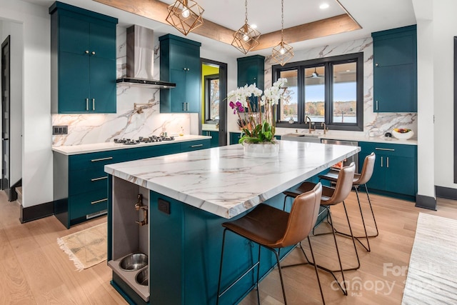 180 Willow Point Rd, Troutman, NC 28166 - kitchen with wall chimney range hood, a kitchen island, light wood-type flooring, backsplash, and a kitchen breakfast bar