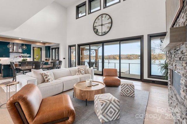 180 Willow Point Rd, Troutman, NC 28166 - living area with a towering ceiling, wood finished floors, a stone fireplace, and a water view