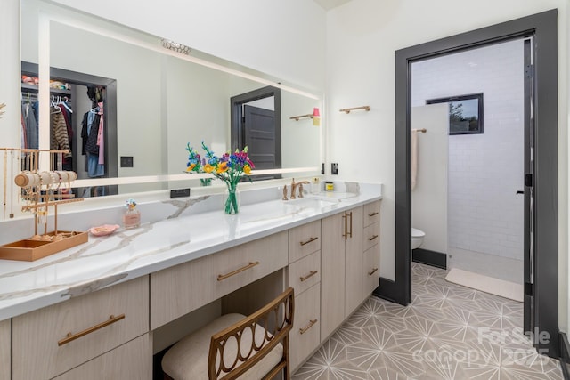 180 Willow Point Rd, Troutman, NC 28166 - bathroom with vanity, tiled shower, a spacious closet, and tile patterned floors