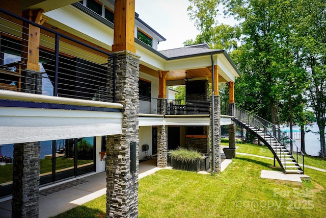 180 Willow Point Rd, Troutman, NC 28166 - back of house featuring stairs, a lawn, a balcony, and stone siding