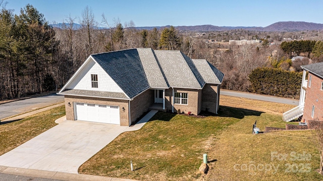 view of front of property featuring a mountain view, a garage, and a front lawn