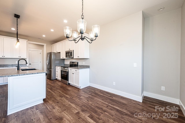 kitchen with pendant lighting, white cabinetry, sink, stainless steel appliances, and light stone countertops