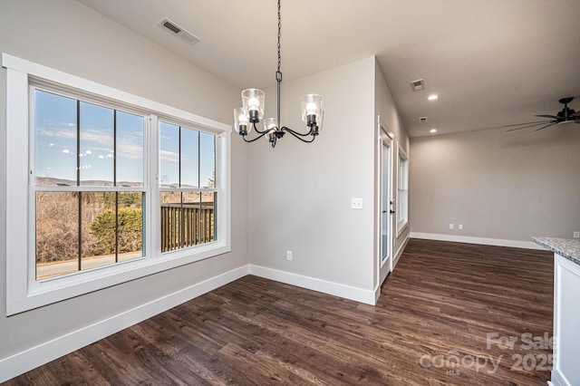 unfurnished dining area with dark wood-type flooring and ceiling fan with notable chandelier