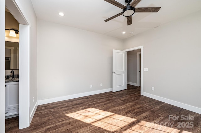 unfurnished bedroom with ceiling fan, dark hardwood / wood-style floors, sink, and ensuite bath