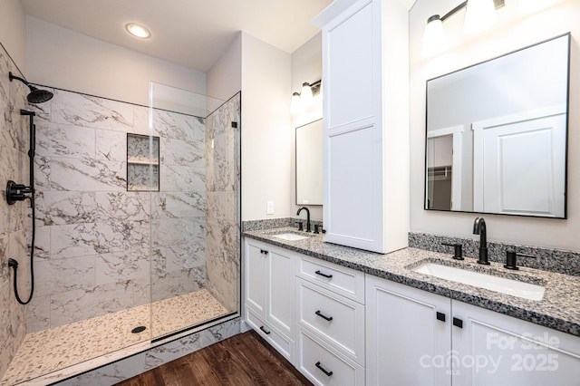 bathroom with vanity, hardwood / wood-style floors, and a tile shower