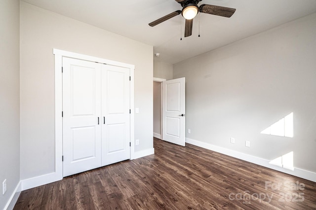 unfurnished bedroom with dark hardwood / wood-style flooring, a closet, and ceiling fan